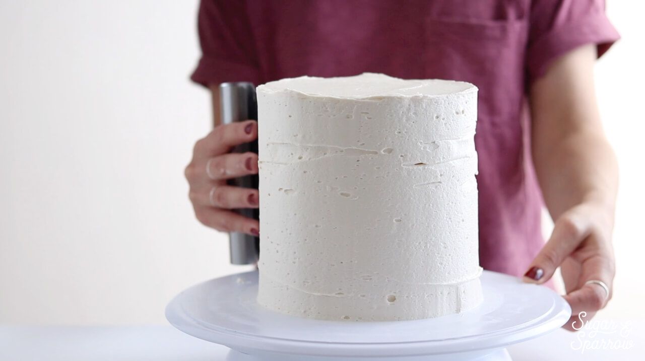 using a bench scraper to frost a cake