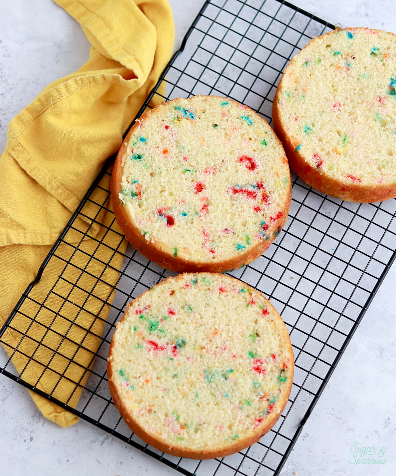 funfetti cake layers on a cooling rack