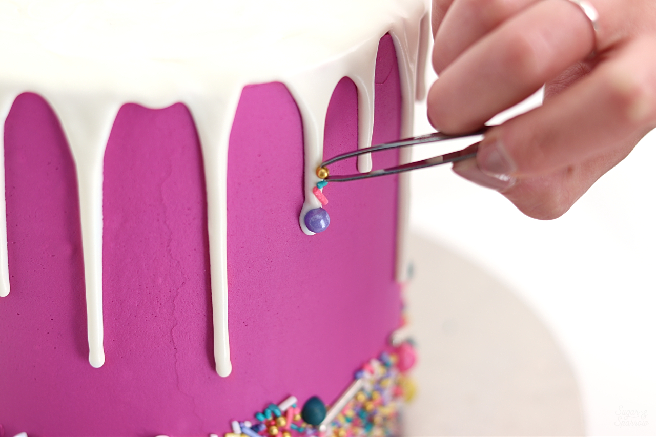 adding sprinkles to drip cake