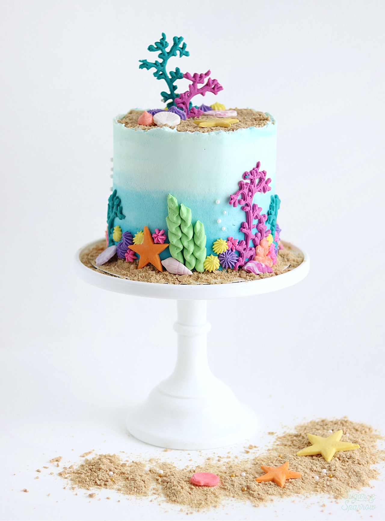 blue ombre cake with seashells and sand  