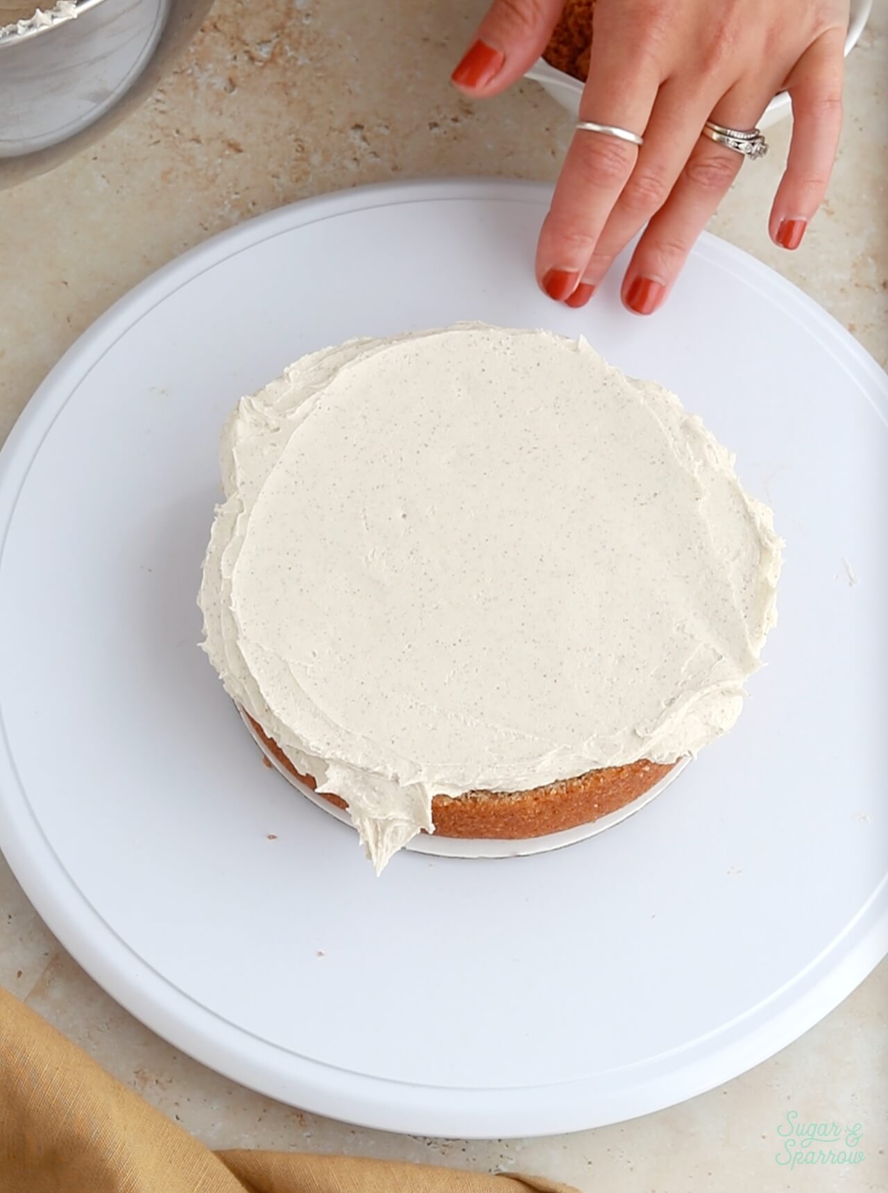 adding buttercream filling on a cake layer
