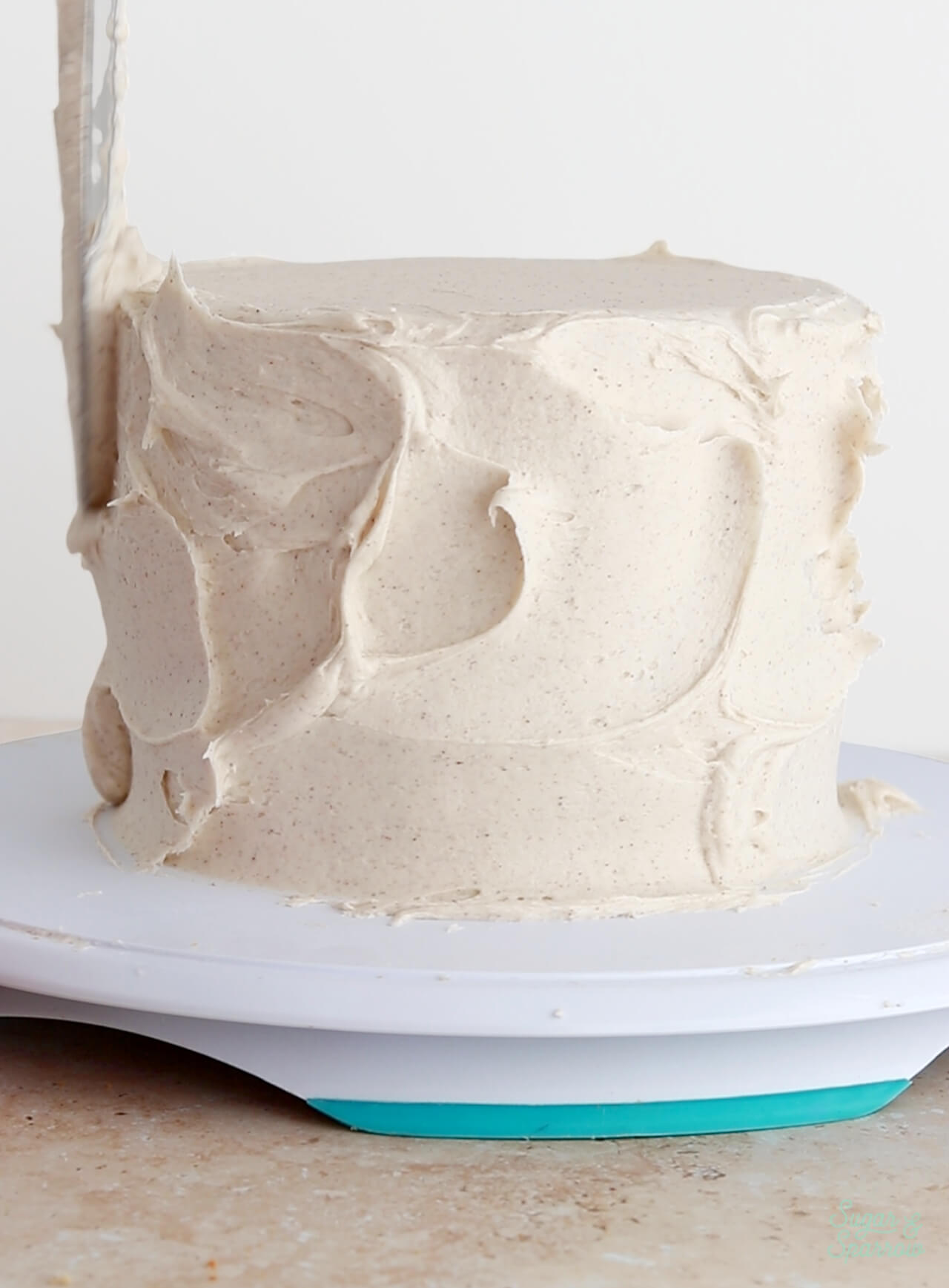 frosting a cake with chai buttercream frosting