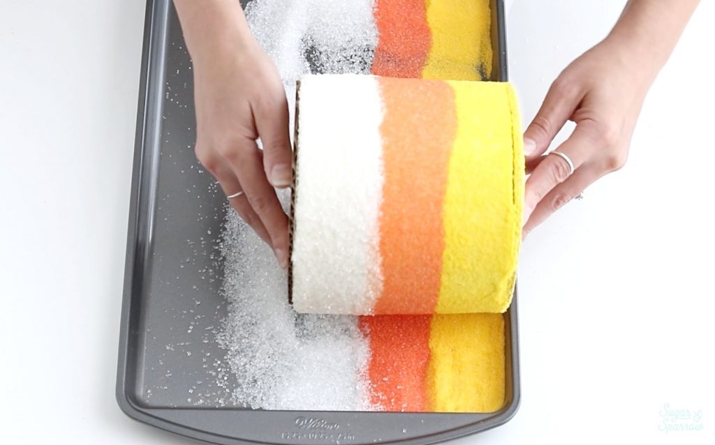 rolling a cake in sugar sprinkles