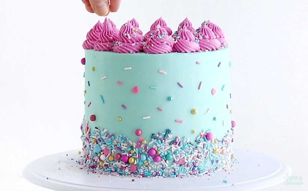 decorating a cake with sprinkles