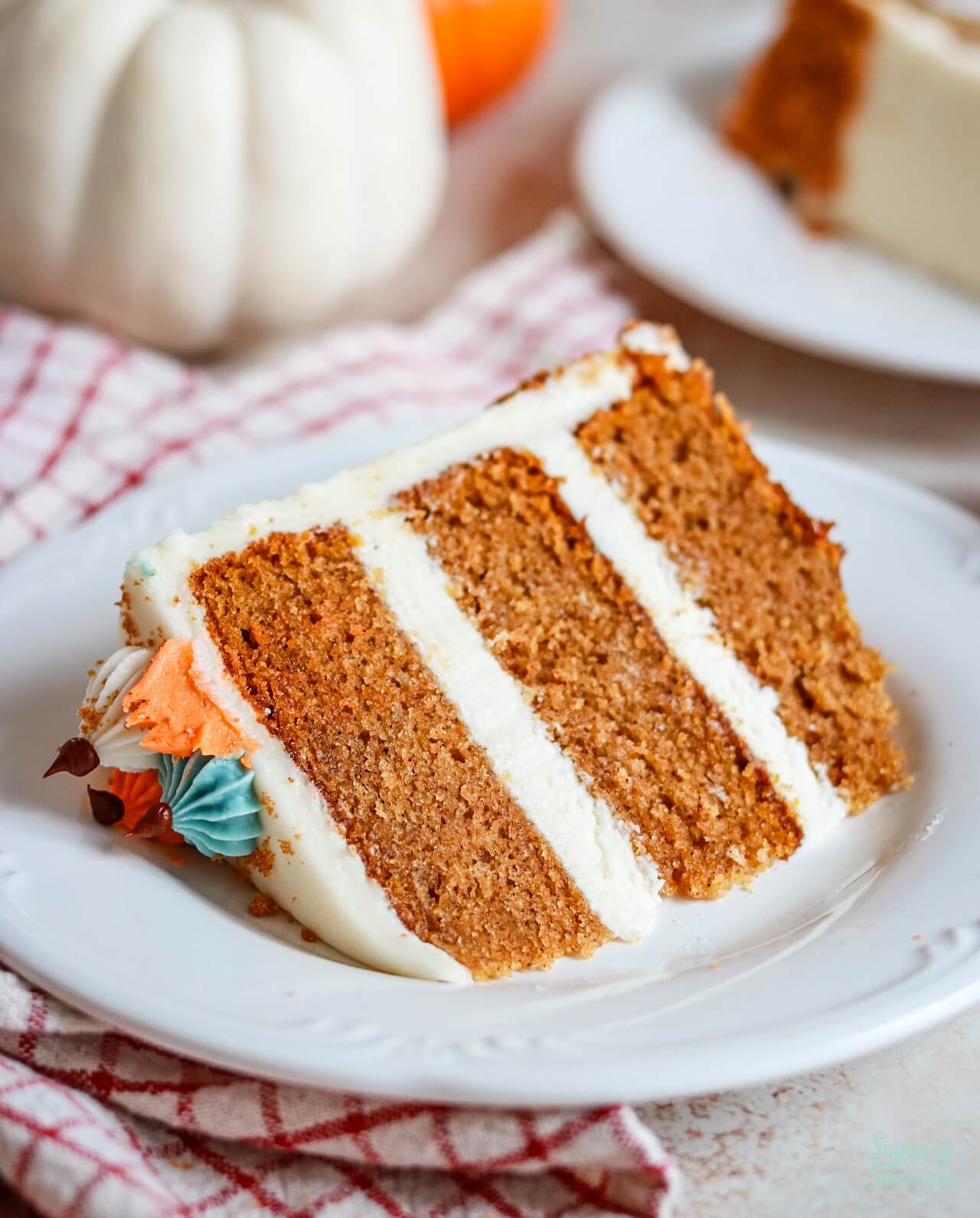 pumpkin layer cake with cream cheese frosting on a plate
