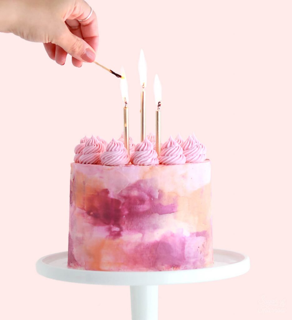 pink birthday cake with watercolor buttercream by sugar and sparrow