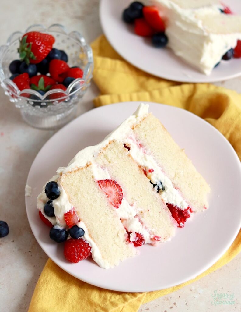 white cake with berries and chantilly cream frosting