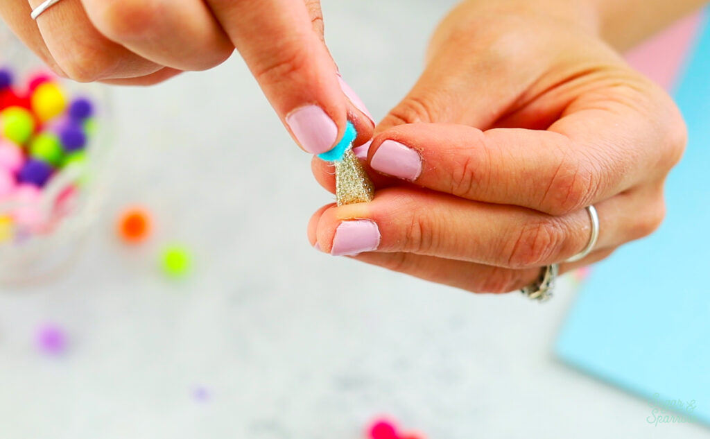 gluing pom pom to mini party hat