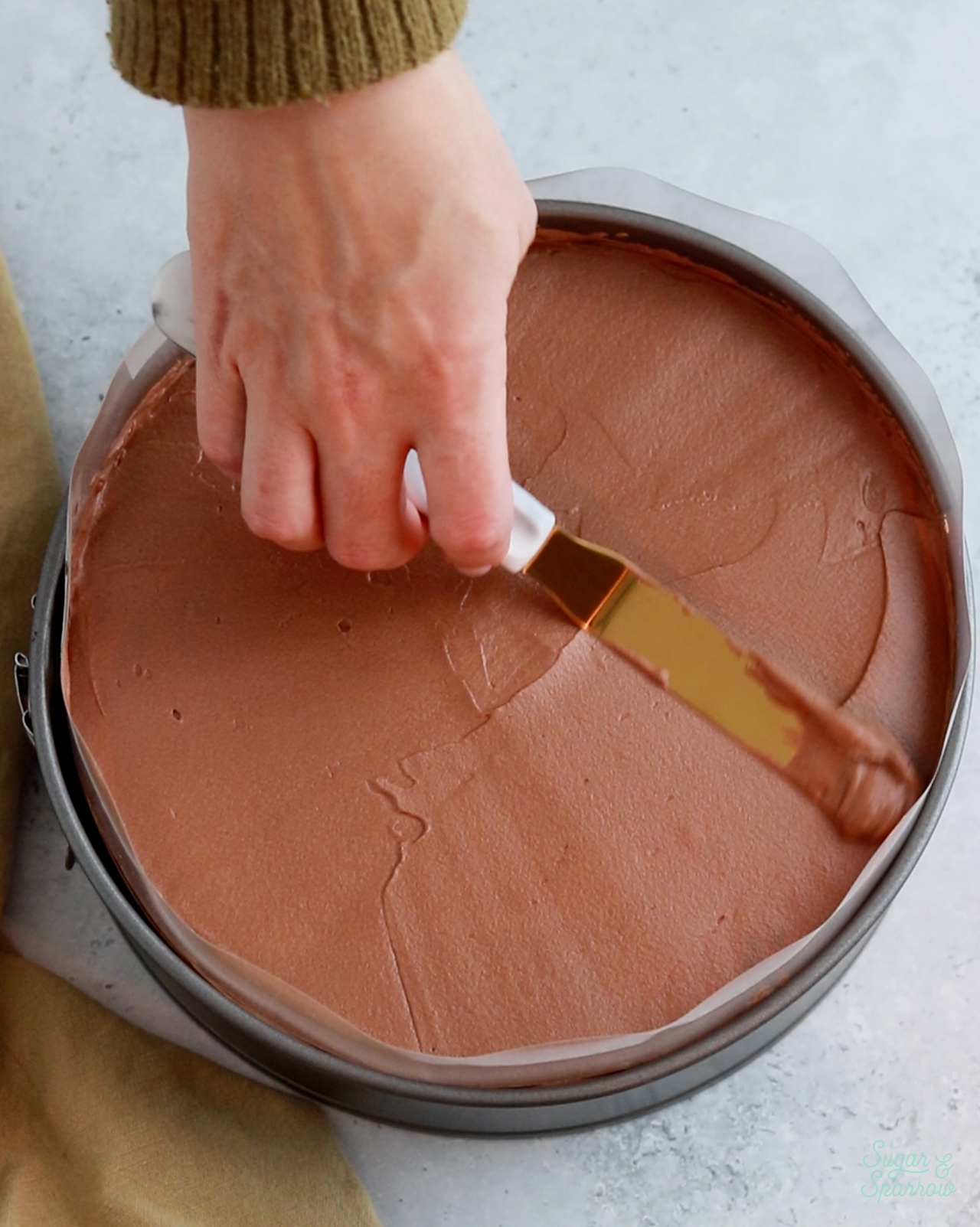 assembling a chocolate mousse cake in a springform pan with acetate collar