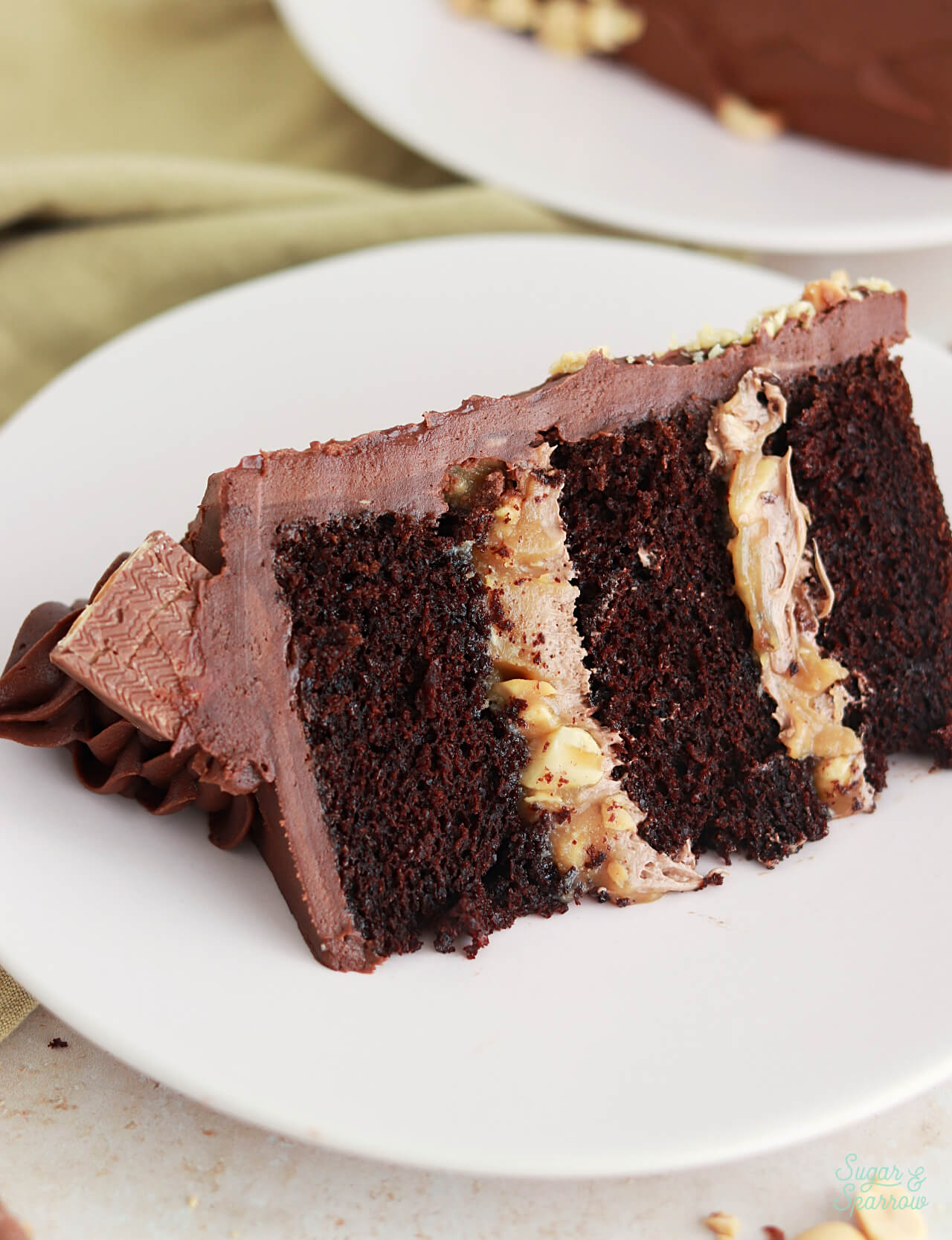 chocolate snickers cake with layers of peanut caramel and chocolate peanut butter nougat