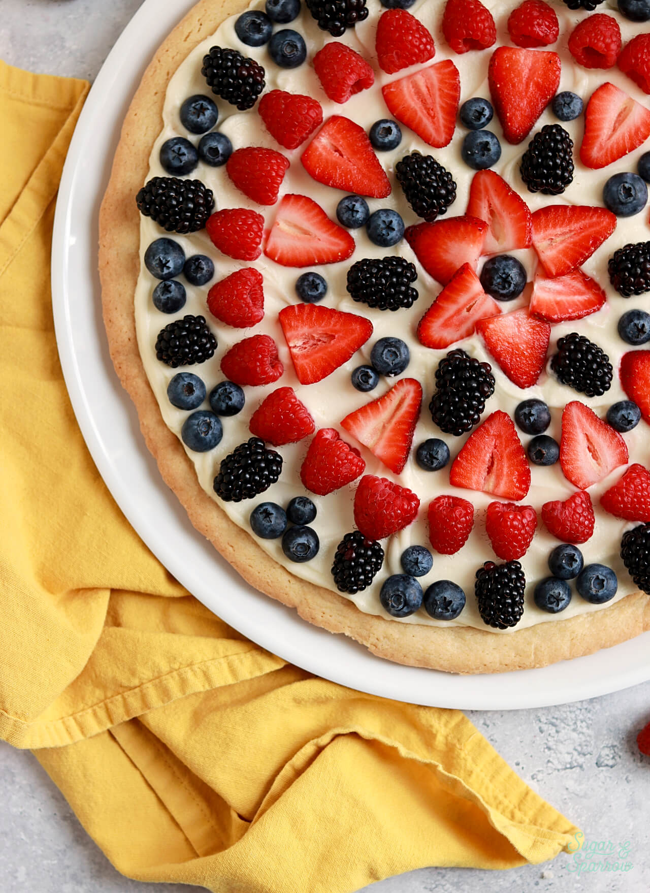 sugar cookie pizza with cream cheese frosting and fresh berries