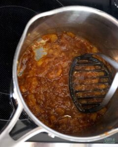mashing cooked peaches for peach filling