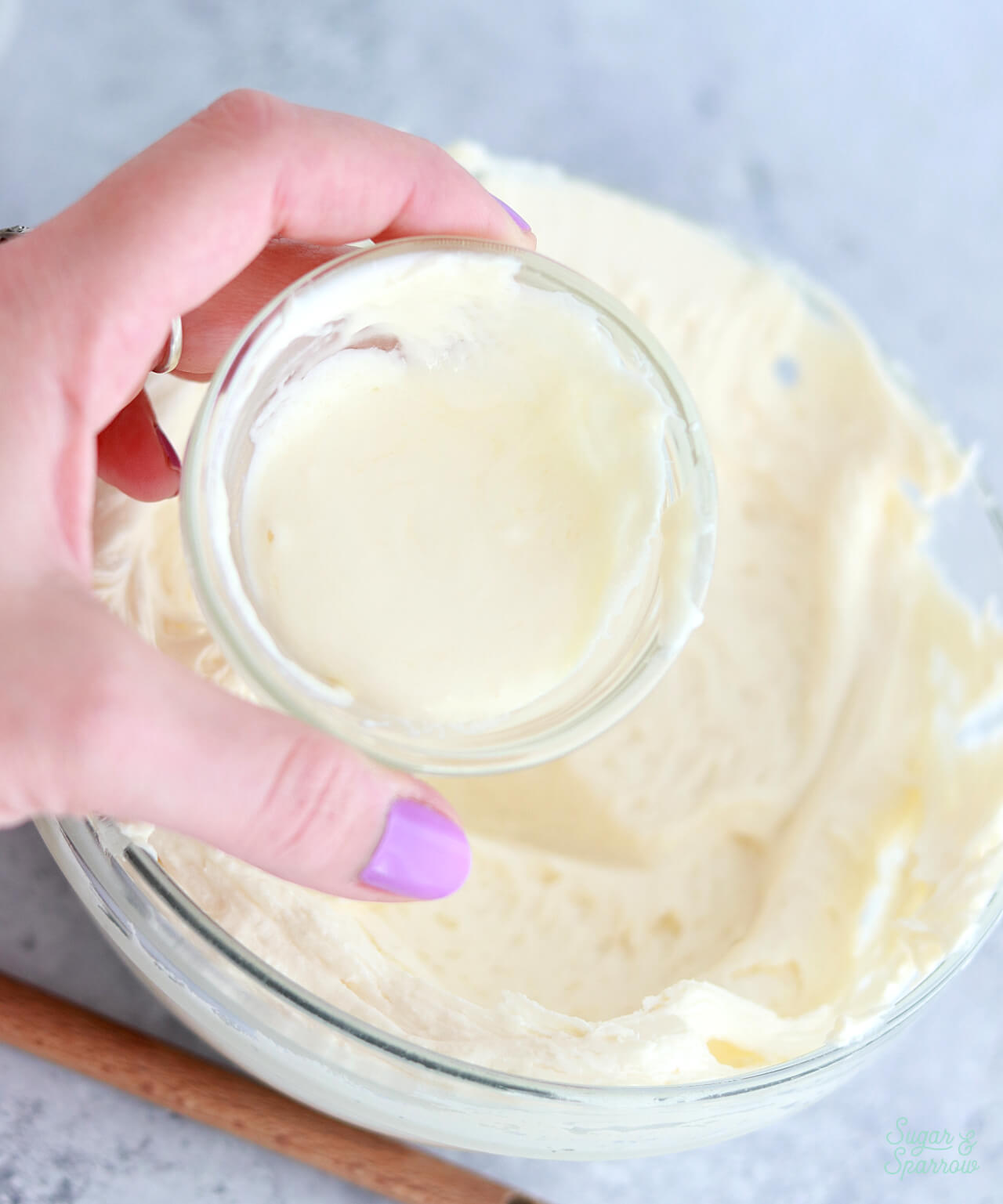 adding melted buttercream to frosting