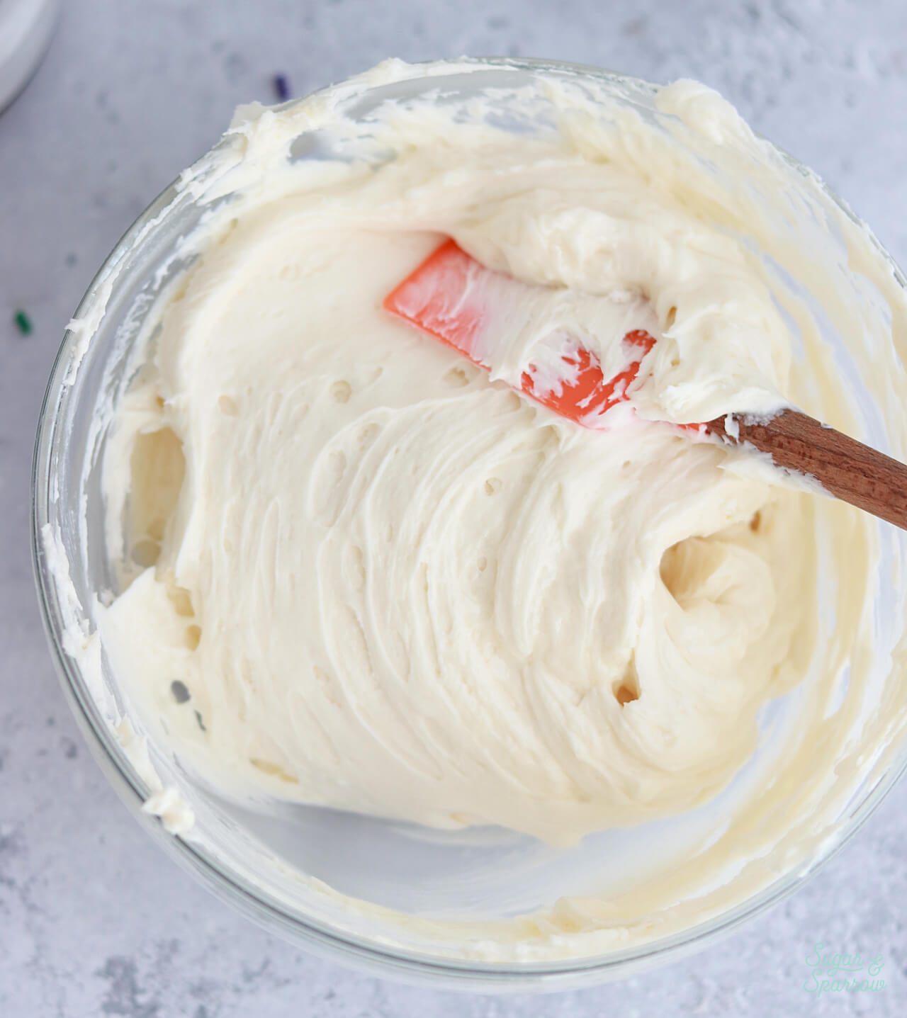 mixing melted buttercream into frosting