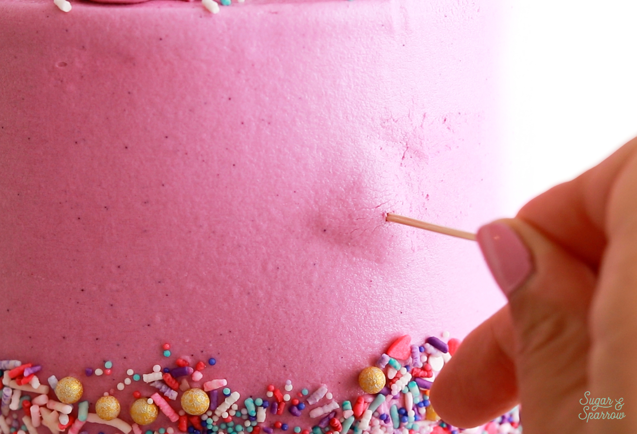 using a toothpick to fix air bubble on a cake