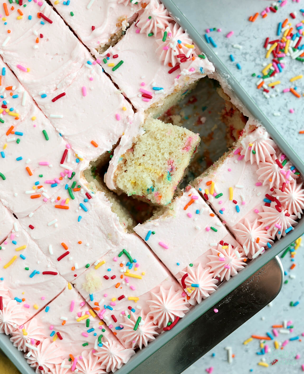 funfetti sheet cake sliced in the pan