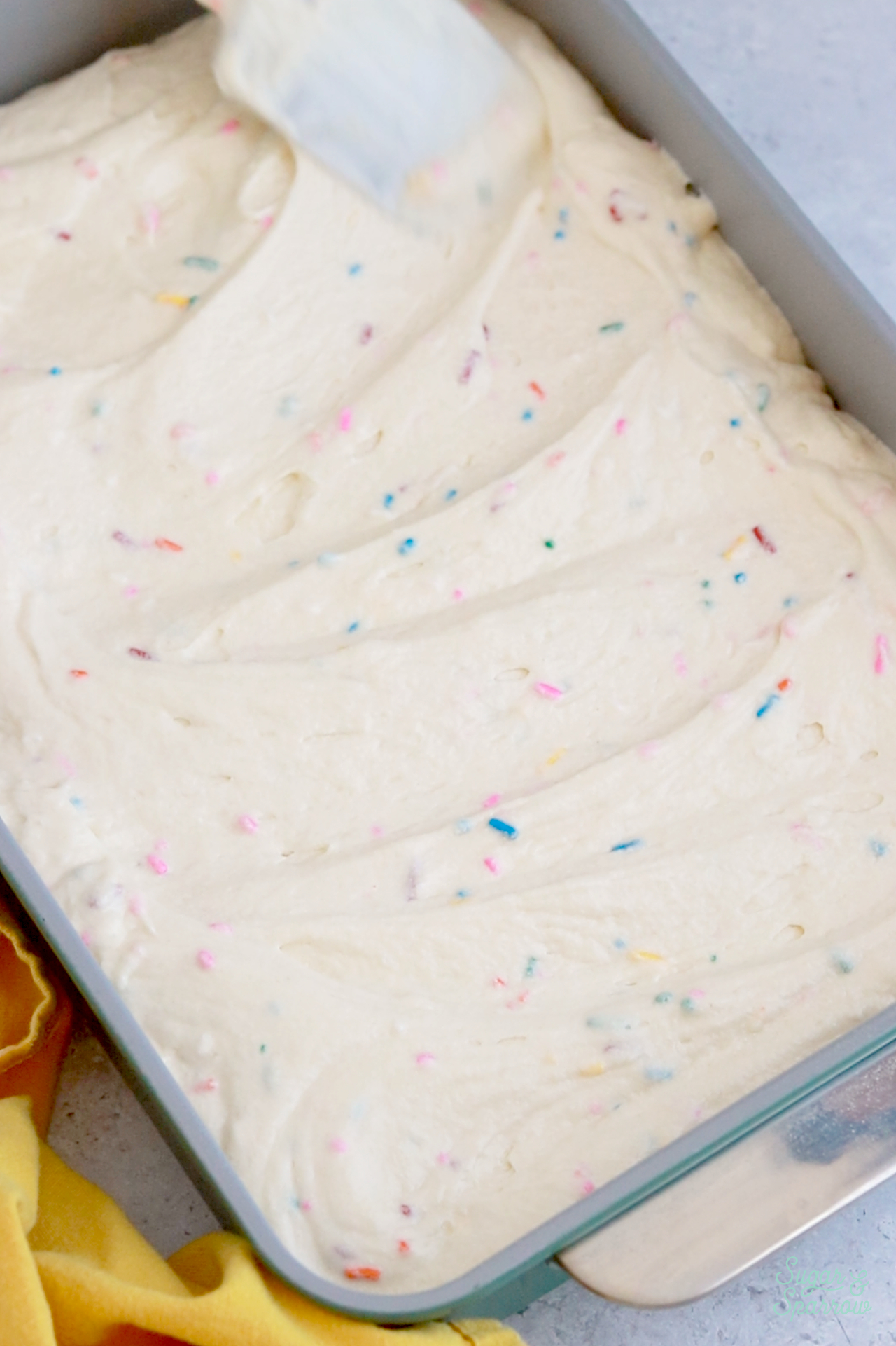 spreading cake batter into a 9x13 pan