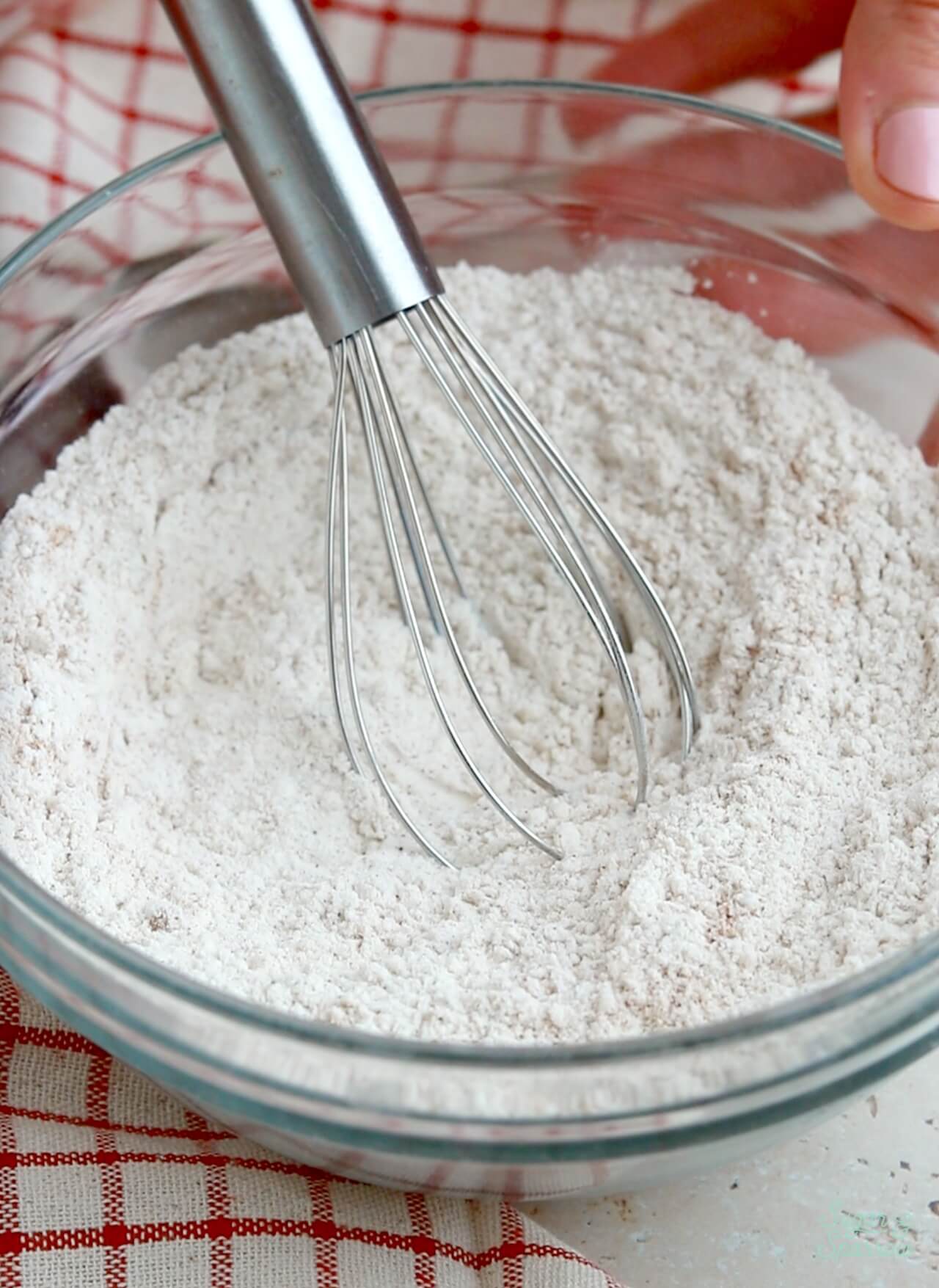 whisking together dry ingredients in a glass bowl