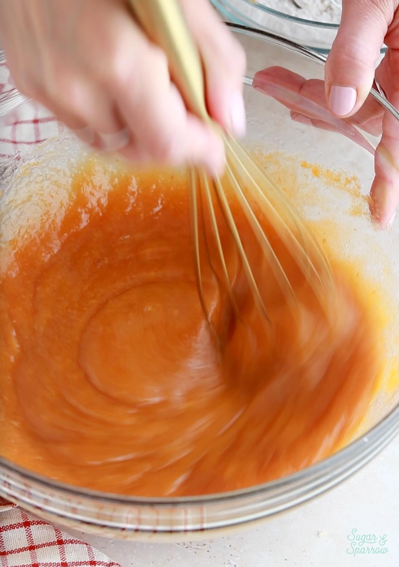 whisking together pumpkin cupcake batter in a bowl
