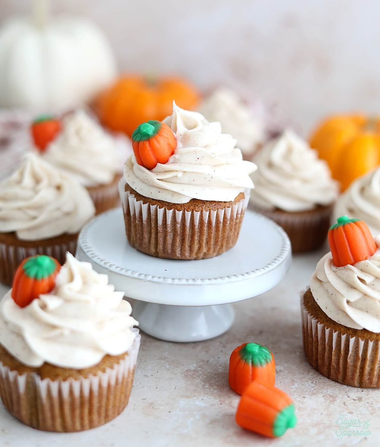 pumpkin cupcakes with cream cheese frosting topped with mini pumpkin candies