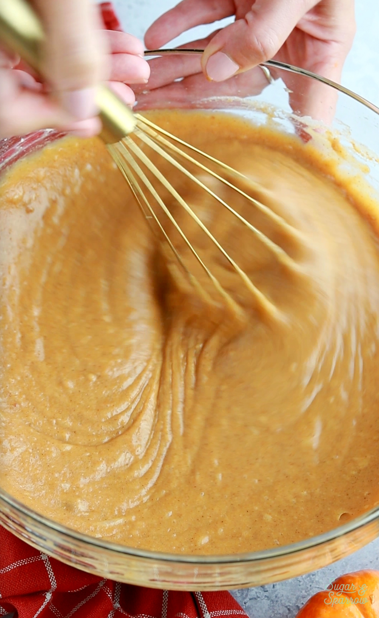 whisking together pumpkin cake batter