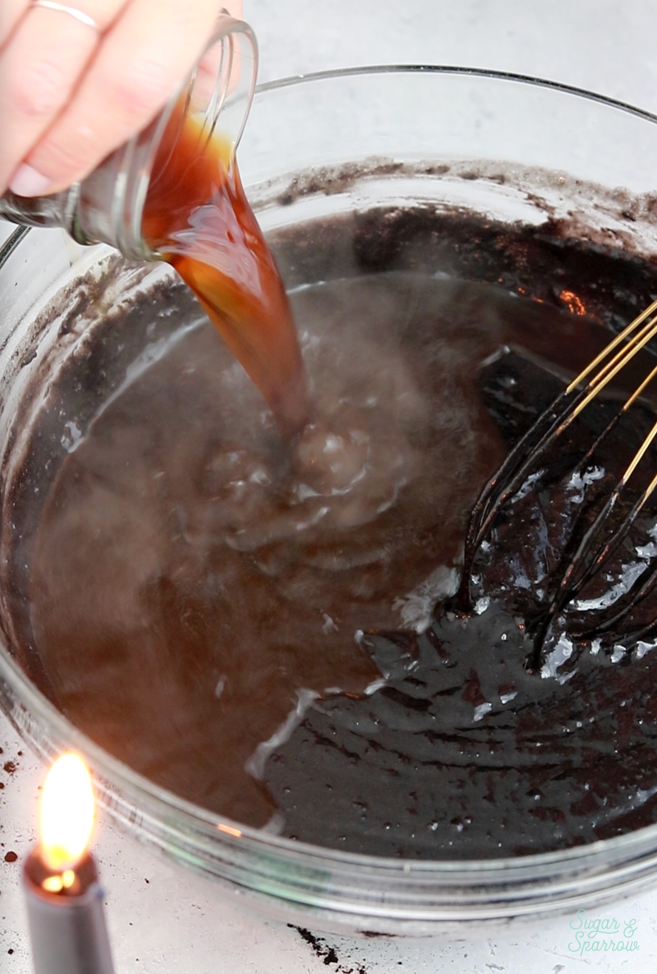 adding hot coffee to chocolate cake batter