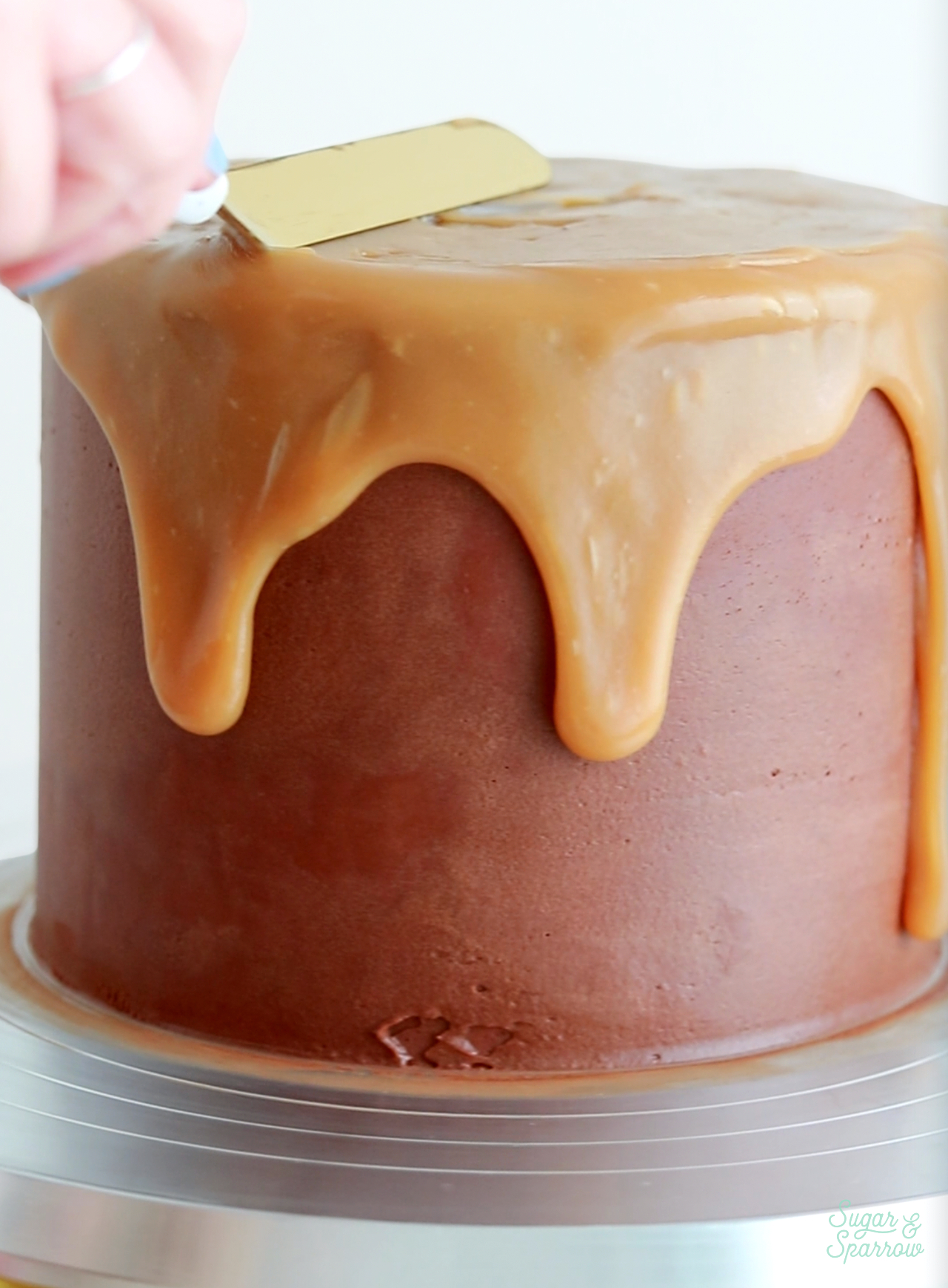 adding a caramel drip to a chocolate cake
