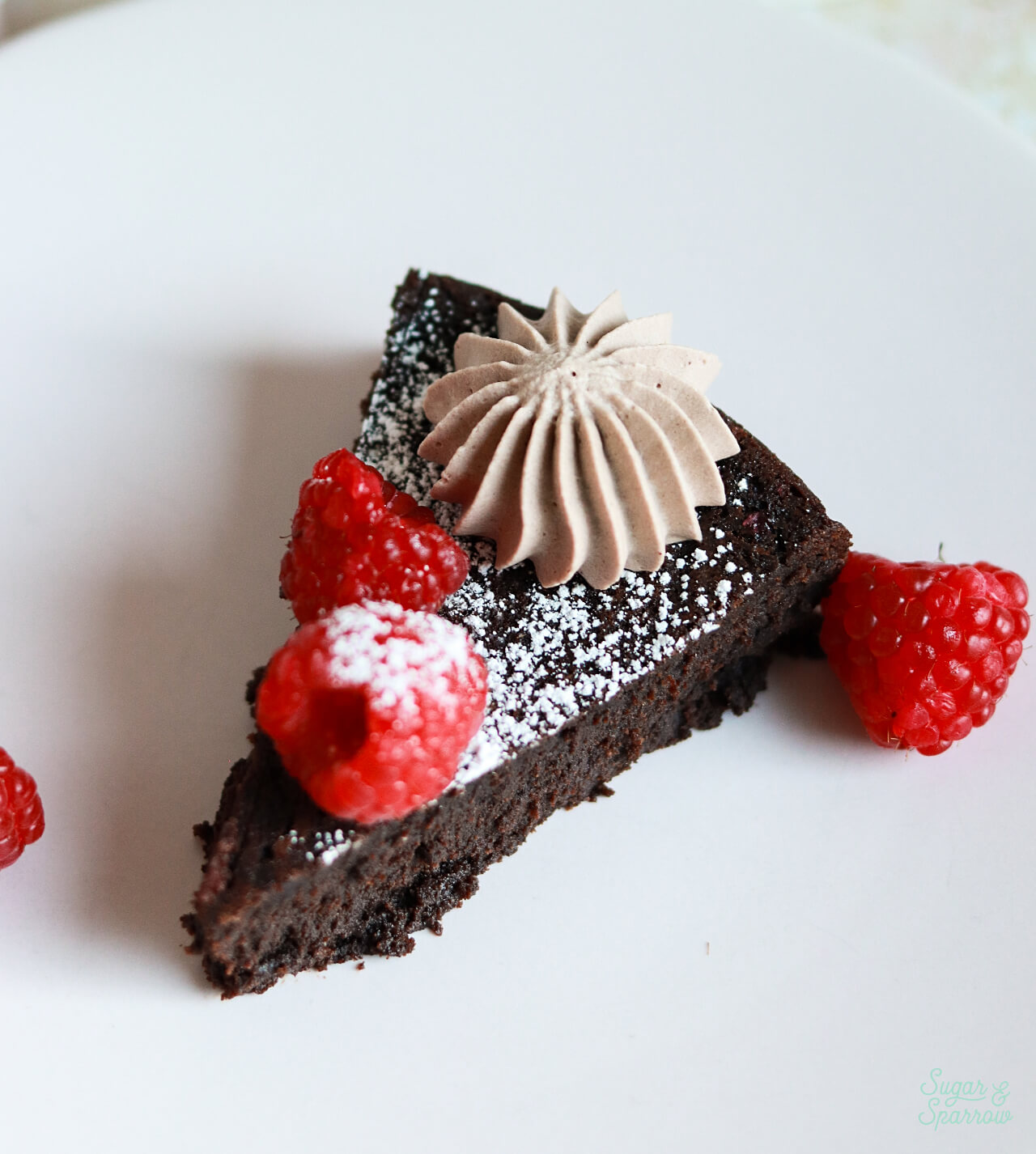 flourless chocolate cake with cocoa whipped cream and raspberries
