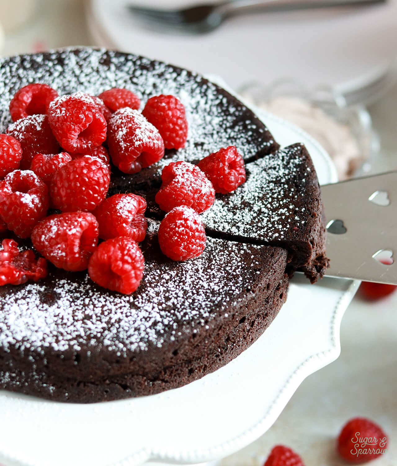 flourless chocolate cake sliced with raspberries
