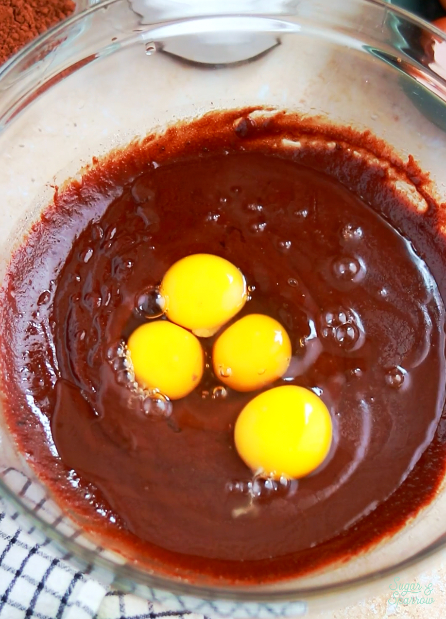 adding eggs to flourless chocolate cake recipe