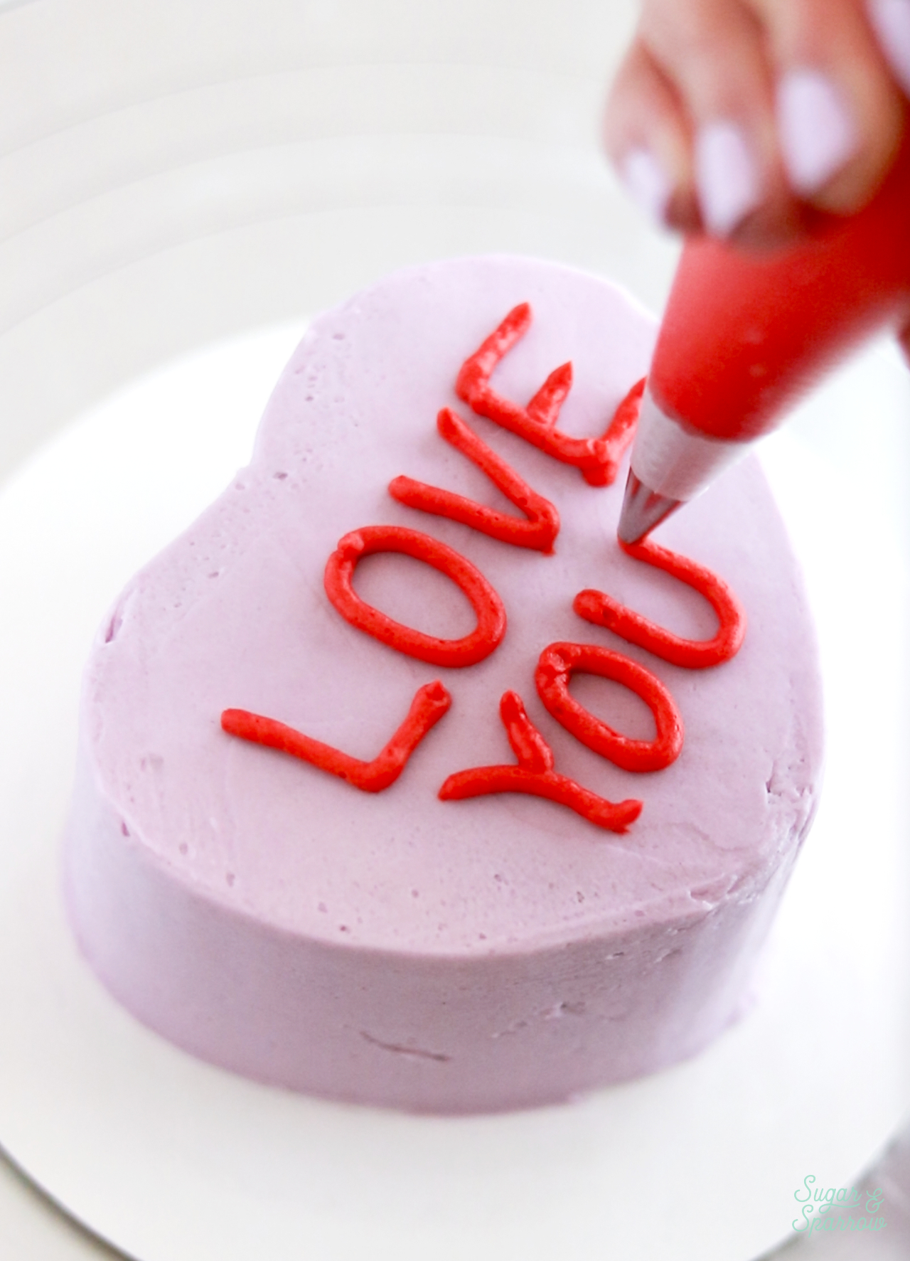 piping message on top of conversation heart cake