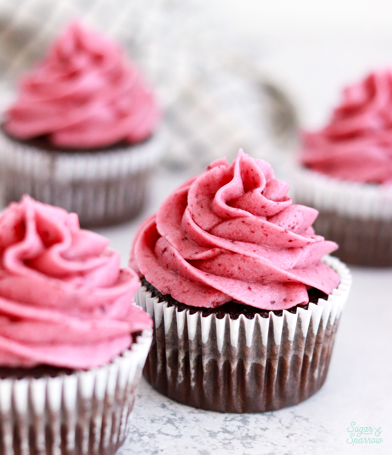 cherry buttercream on chocolate cupcakes