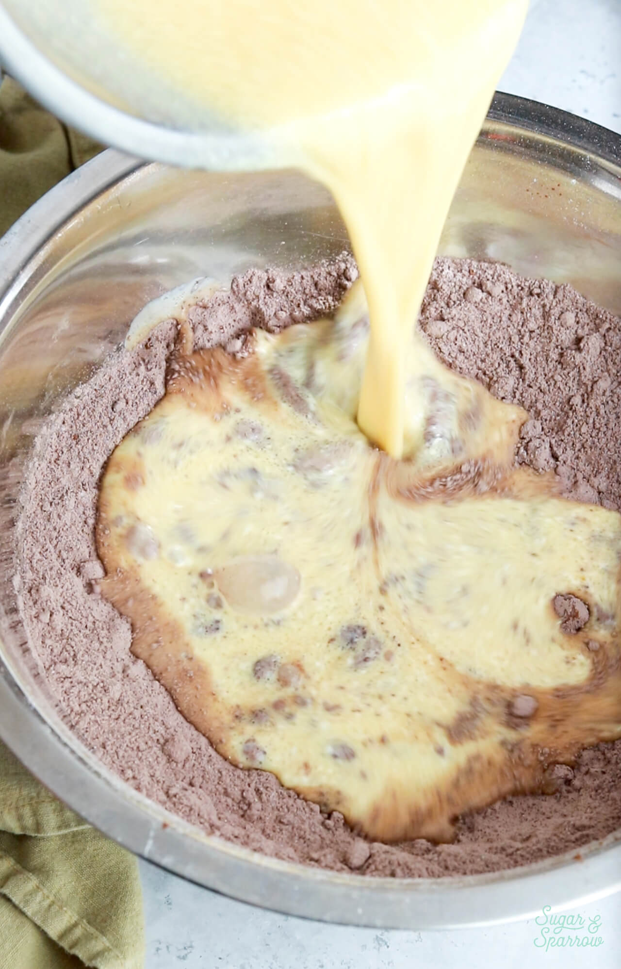Pouring wet ingredients into dry ingredients