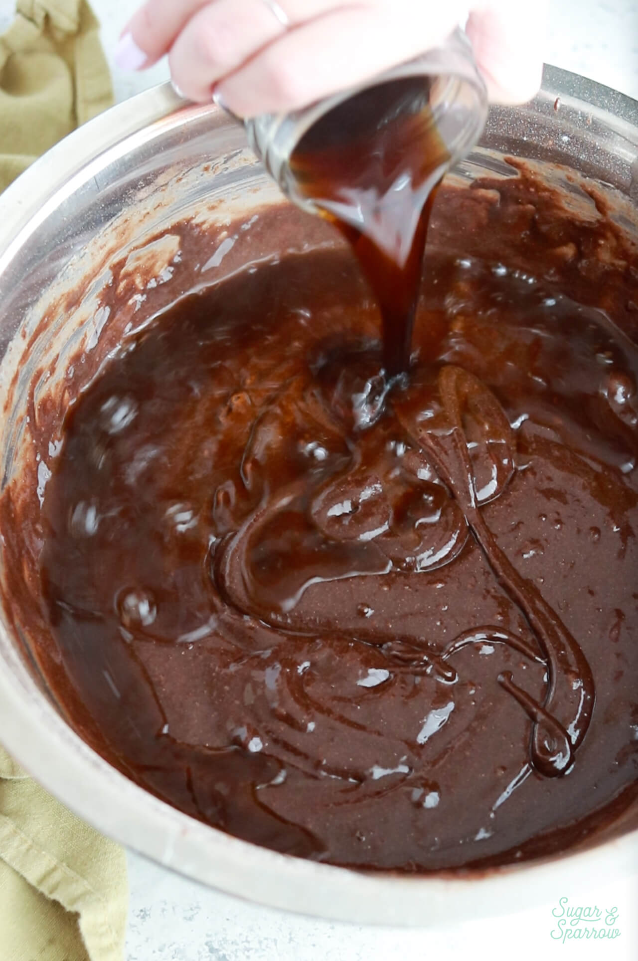 Pouring hot coffee into chocolate cake batter