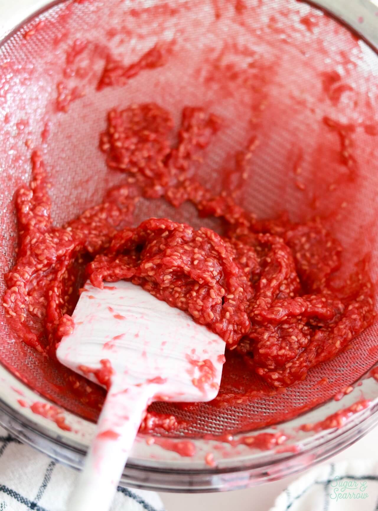 straining seeds out of raspberry filling