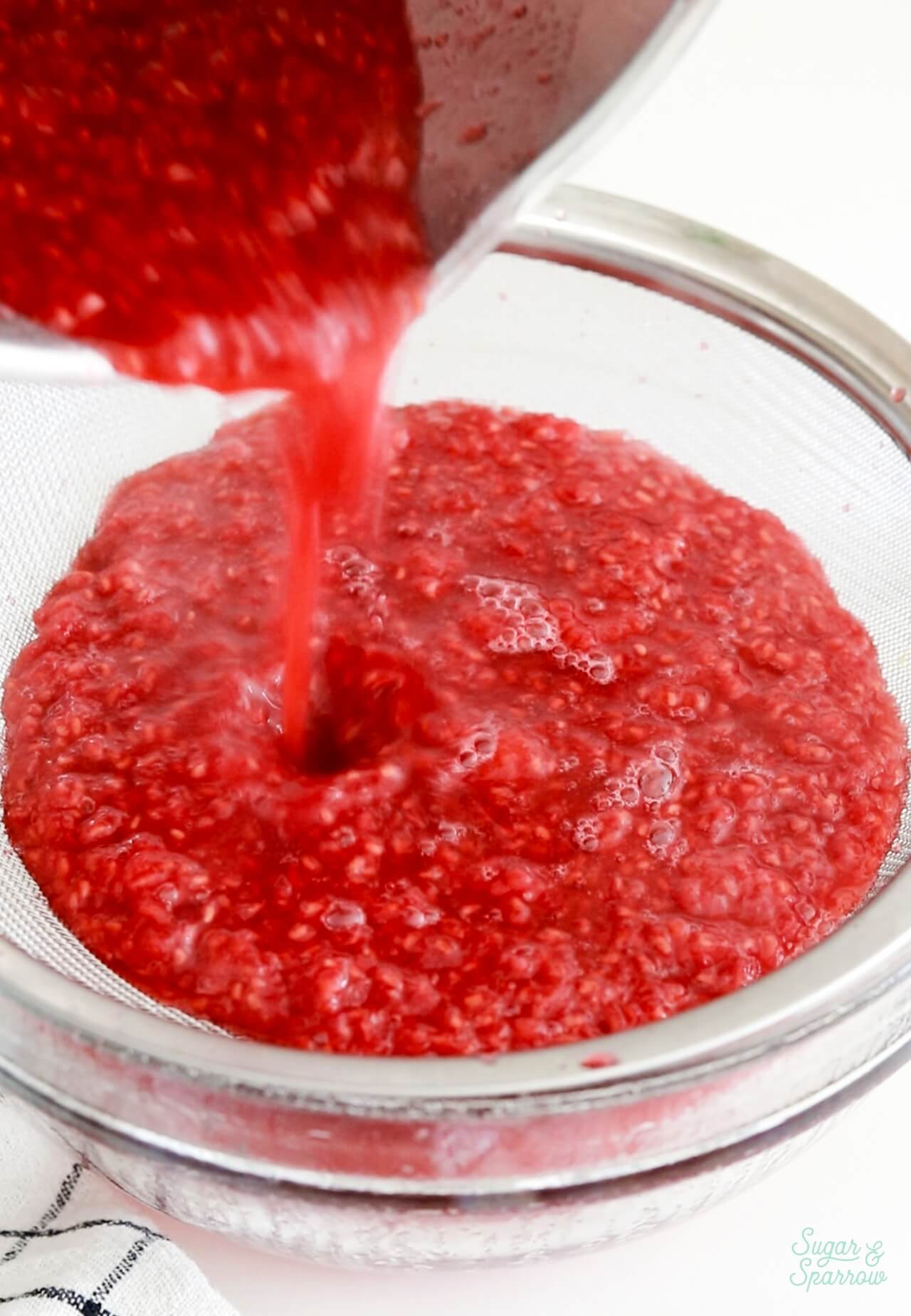 straining seeds out of raspberry cake filling
