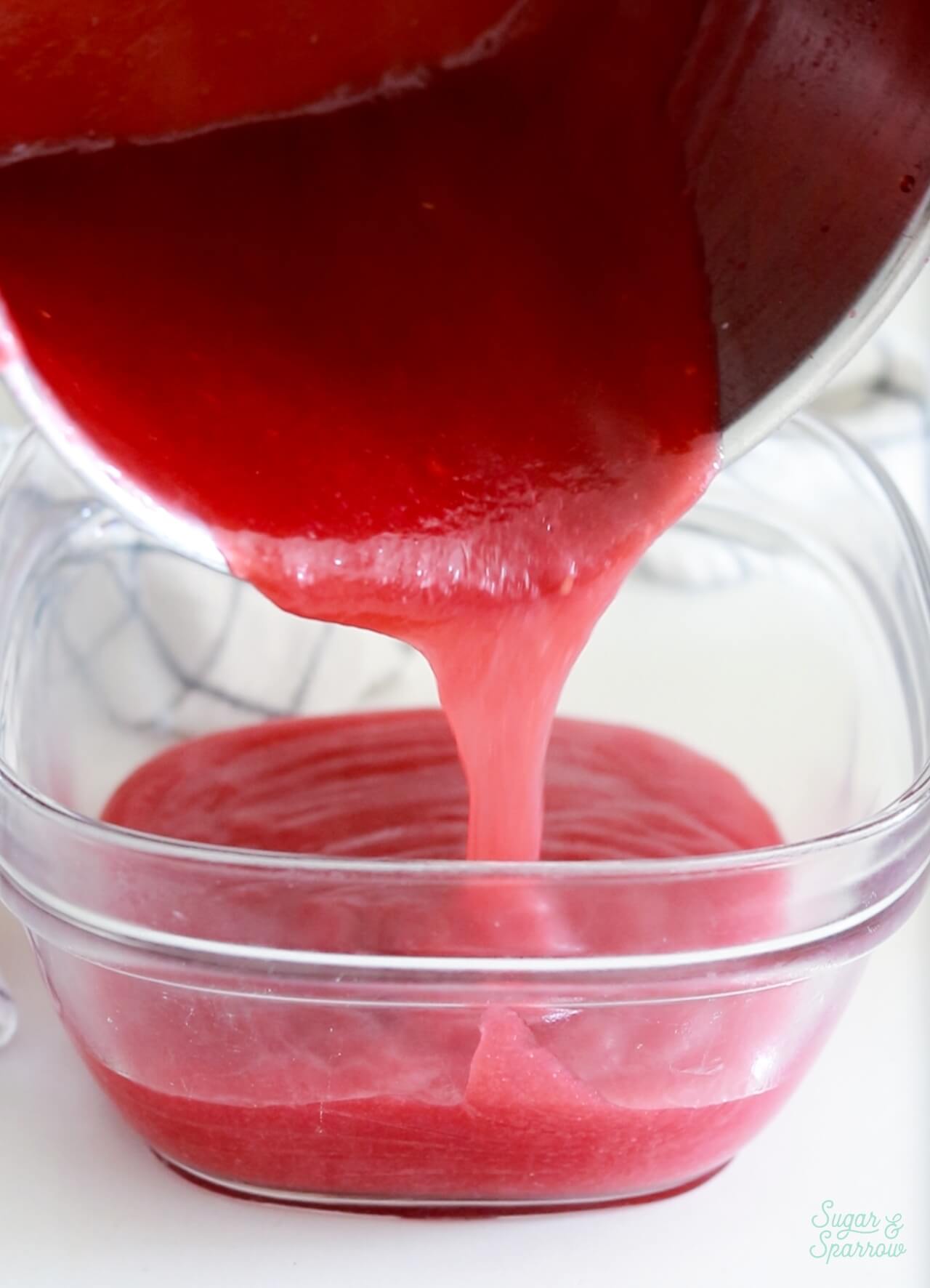 pouring raspberry filling into airtight container