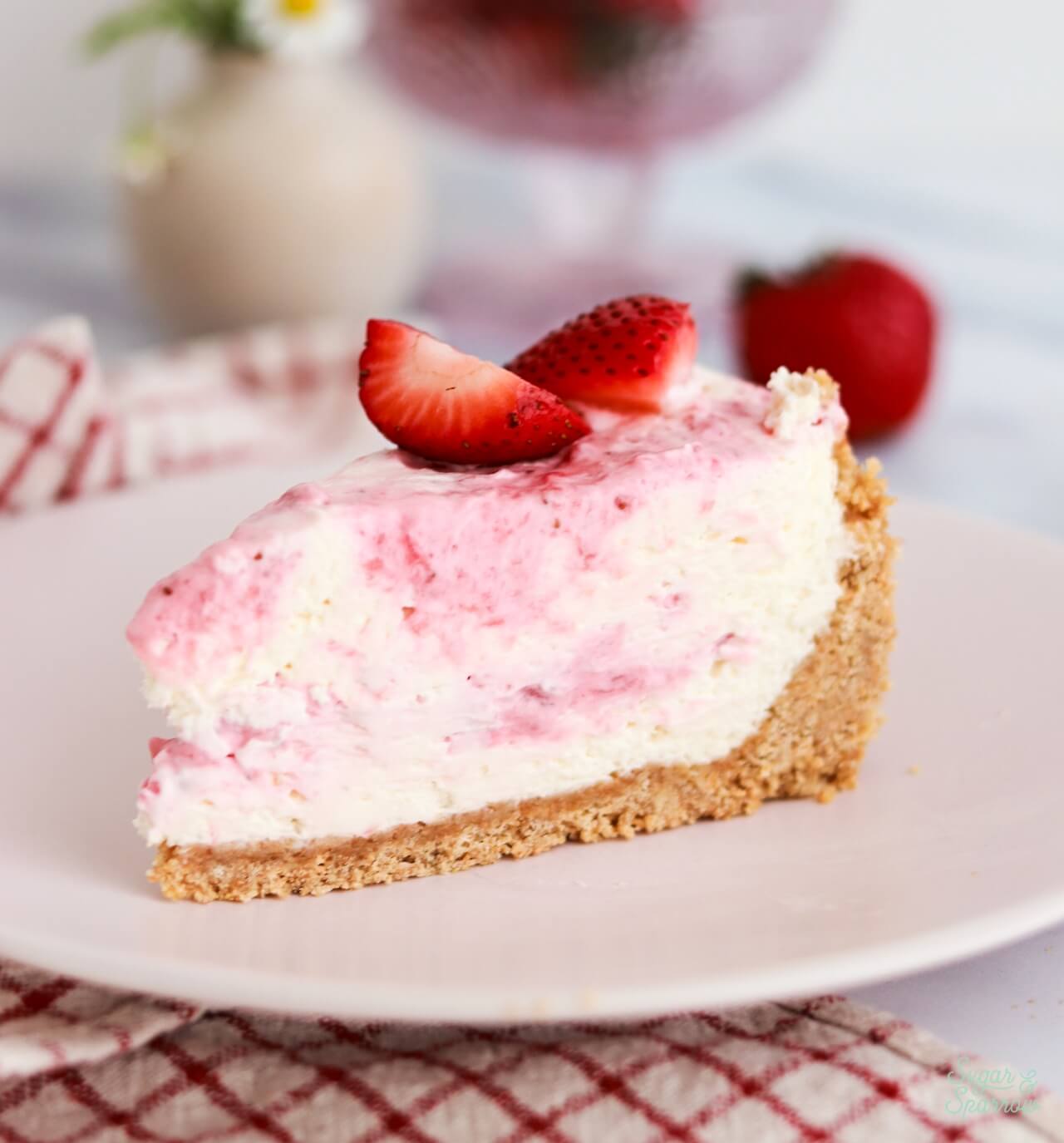 sliced no-bake cheesecake recipe with strawberries on top and strawberry marble
