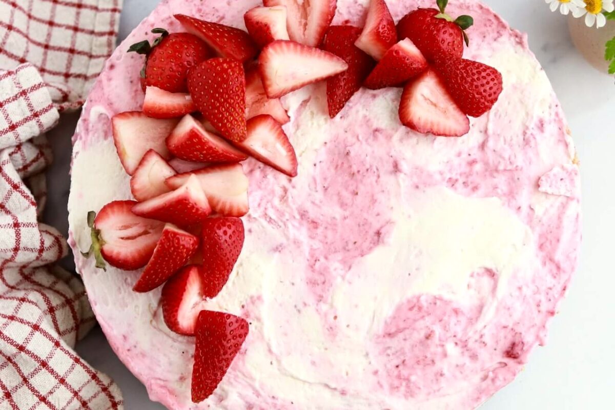 strawberry swirled no-bake cheesecake topped with strawberries