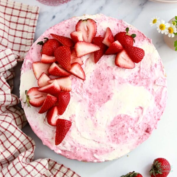 strawberry swirled no-bake cheesecake topped with strawberries