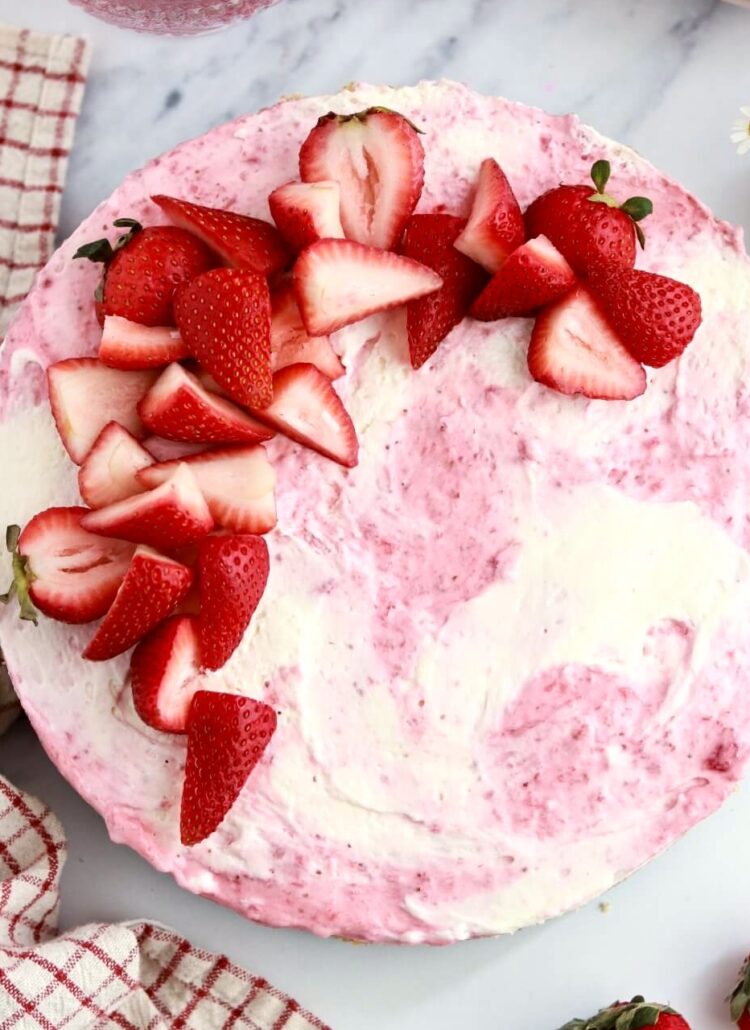 strawberry swirled no-bake cheesecake topped with strawberries