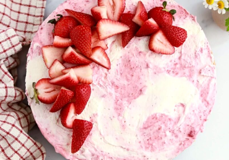 strawberry swirled no-bake cheesecake topped with strawberries