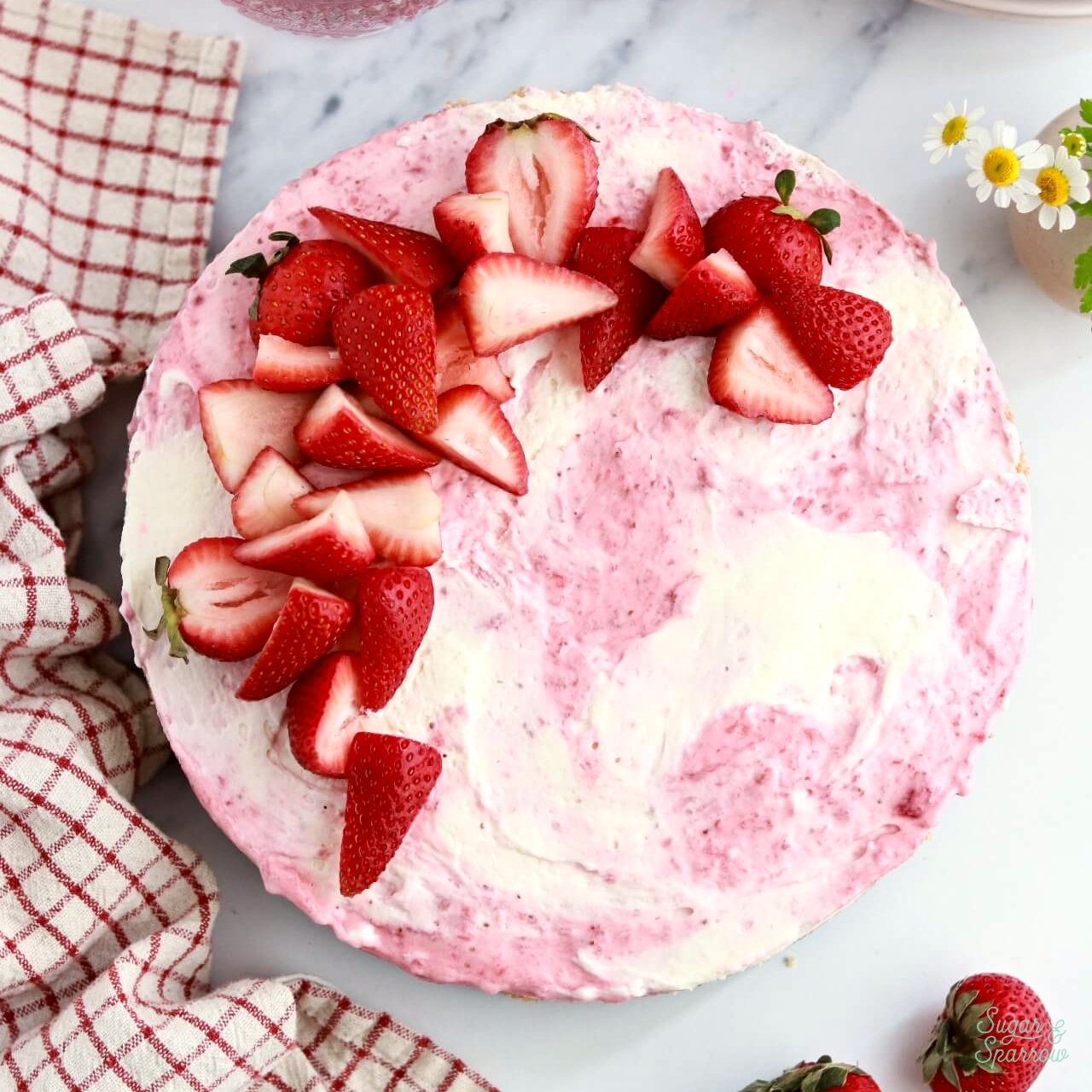 strawberry swirled no-bake cheesecake topped with strawberries