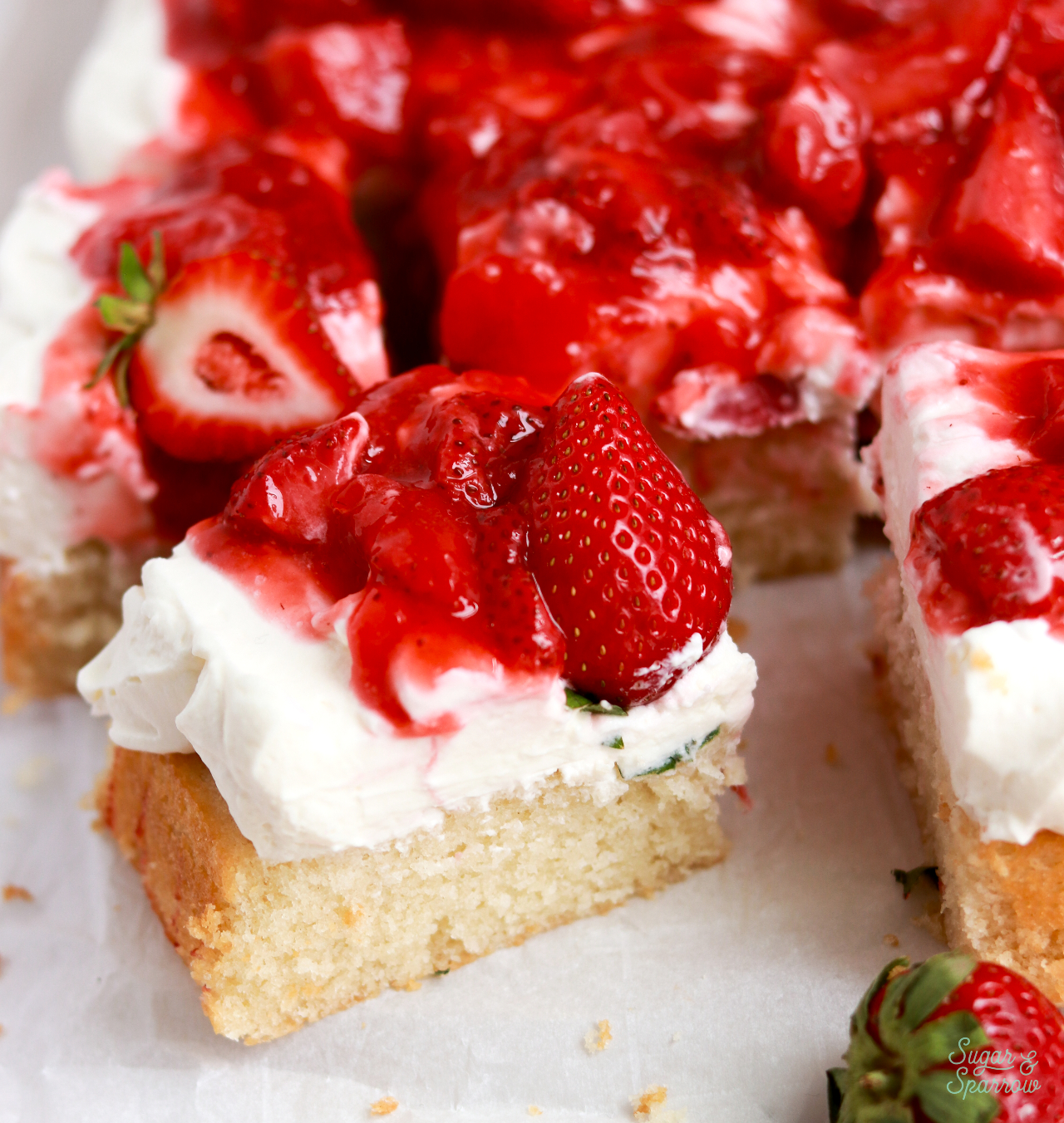 vanilla sheet cake with whipped cream frosting and strawberry topping