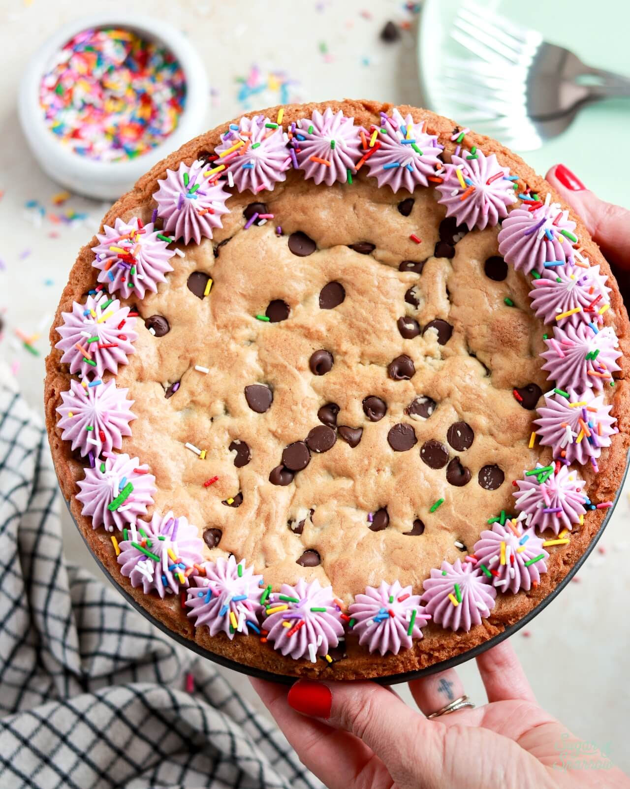 chocolate chip cookie cake recipe with buttercream border and sprinkles
