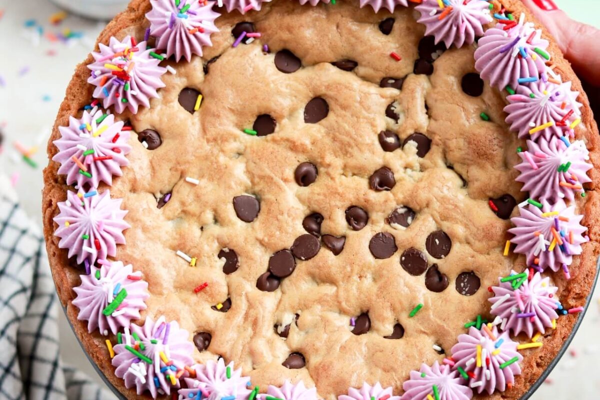 chocolate chip cookie cake recipe with vanilla buttercream border and sprinkles