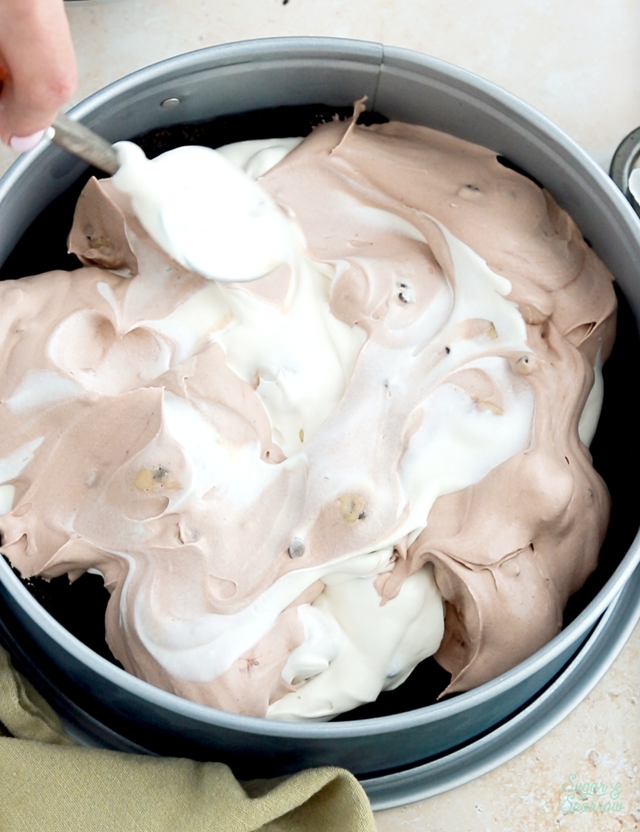 making no-churn ice cream cake with chocolate and vanilla ice cream swirled