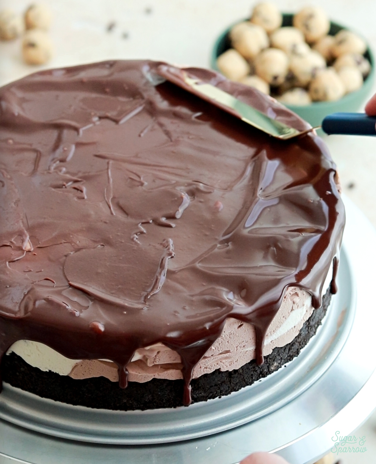 topping ice cream cake with chocolate ganache drips