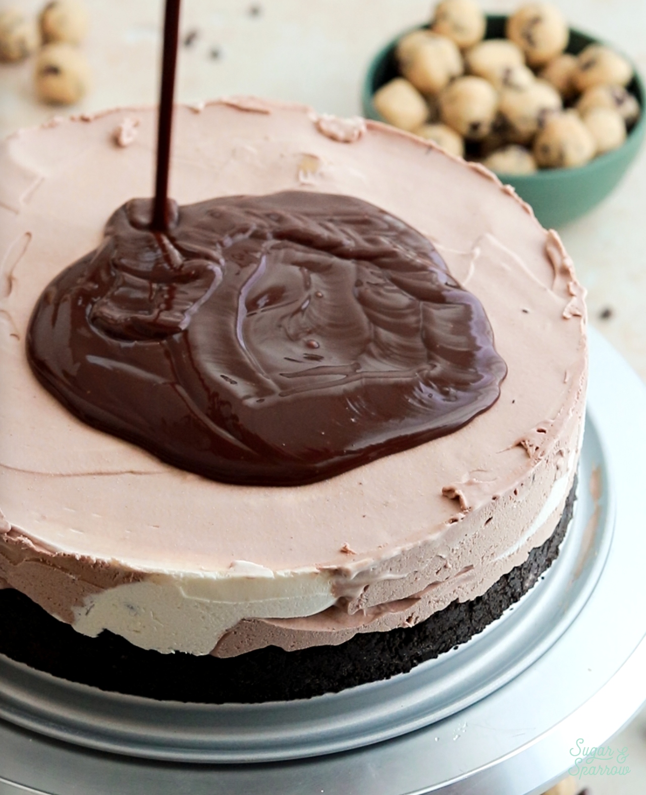 pouring chocolate ganache onto ice cream cake