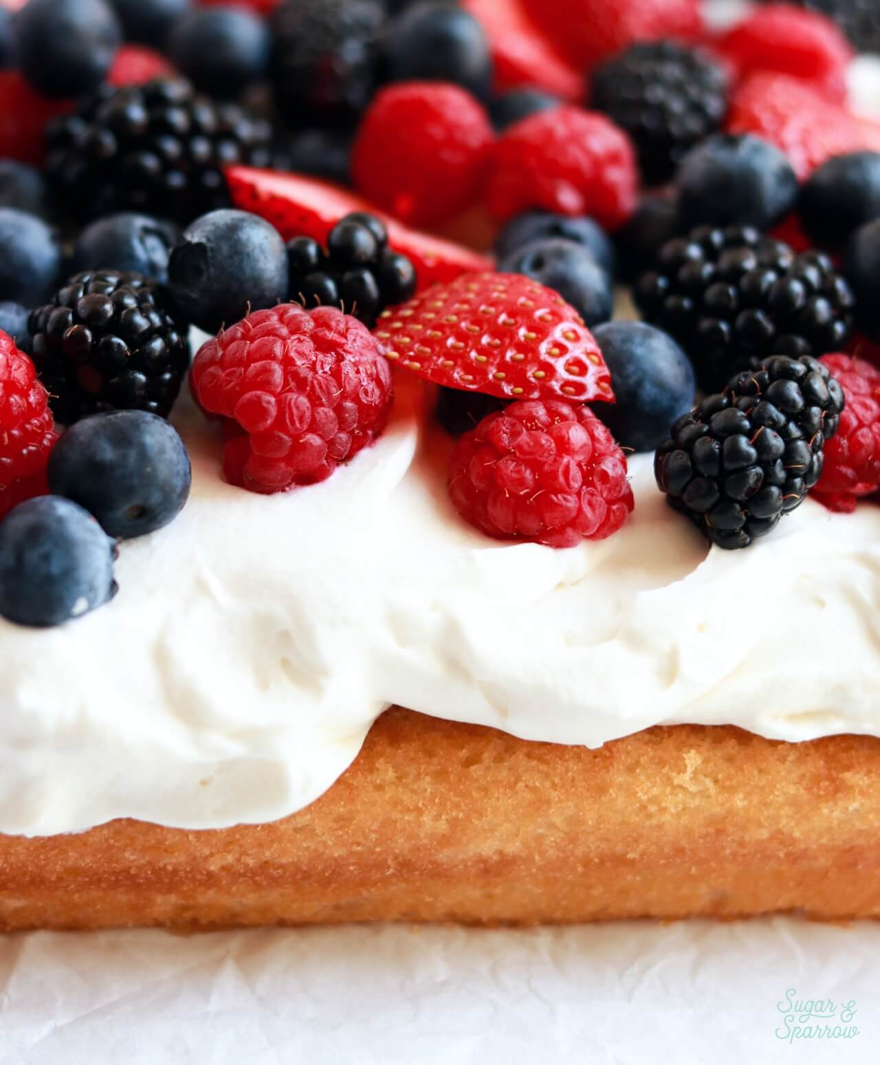 soft vanilla cake with whipped cream frosting with berries